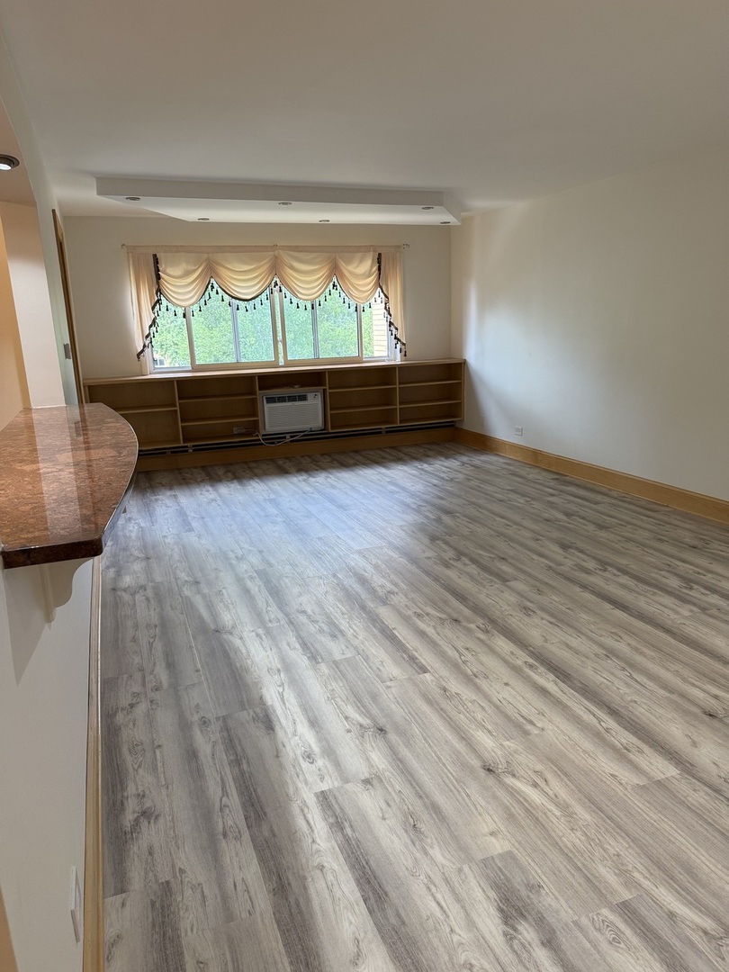 728 Dempster Street, Unit 210 Mount Prospect, IL 60056 - Photo 10 of 27 a view of room with window and wooden floor