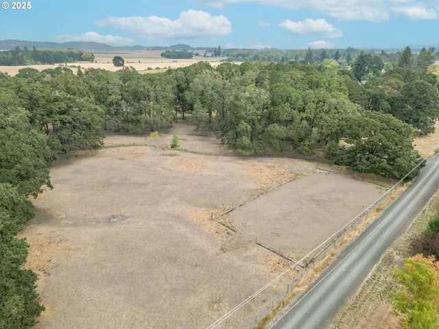 a view of a dry yard with wooden fence