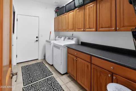 a spacious bedroom with a bed a couch and a chandelier