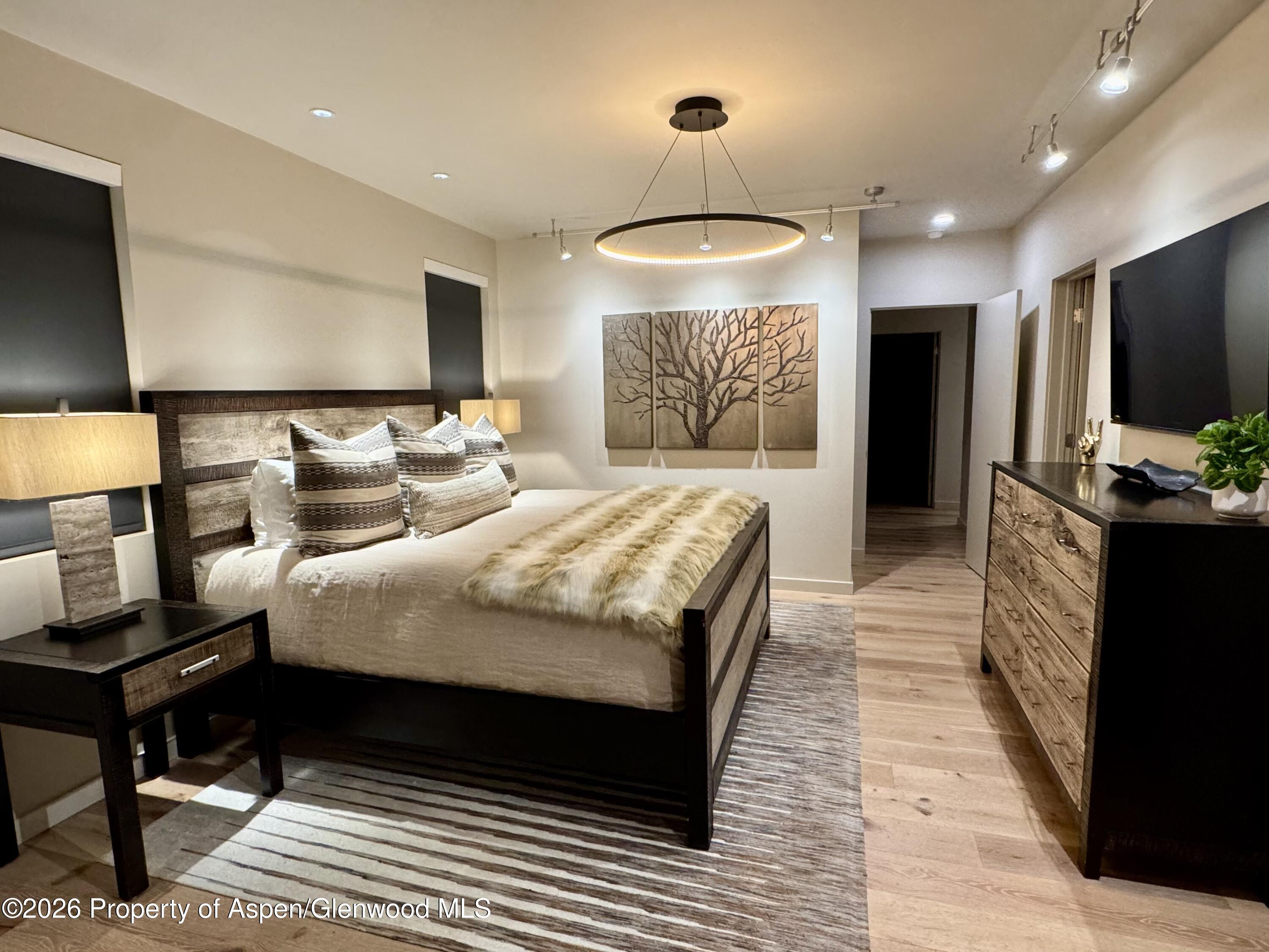 129 Valley Court Basalt, CO 81621 - Photo 20 of 26 a spacious bedroom with a bed and a chandelier