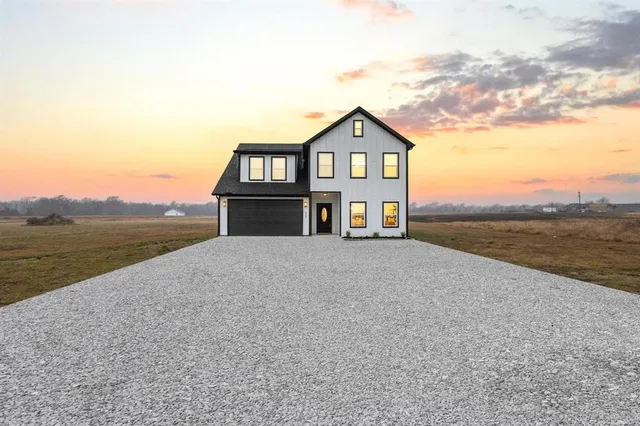 a front view of a house with a yard and lake view