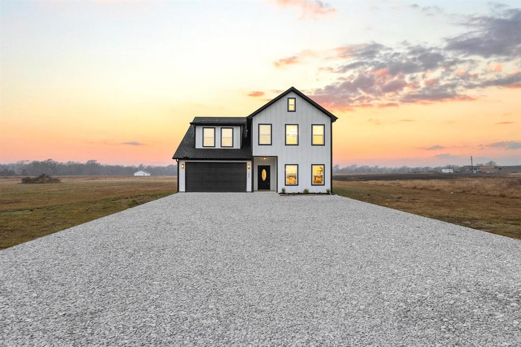 a front view of a house with a yard and lake view