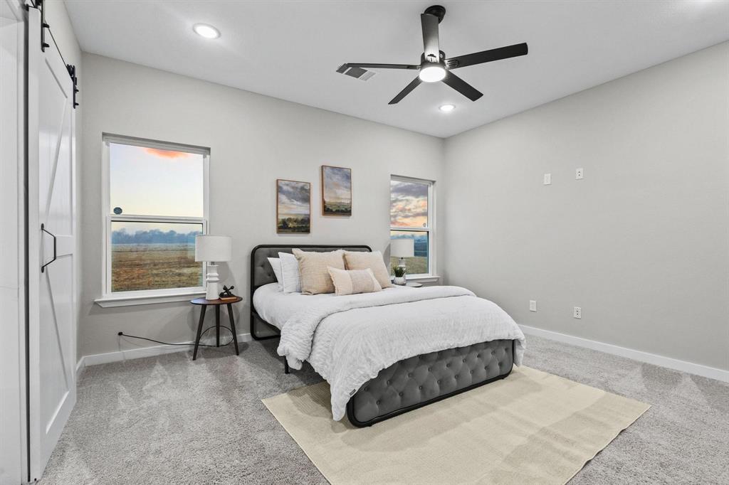 3632 County Road Blossom, TX 75416 - Photo 16 of 36 a bedroom with a large bed and a chandelier