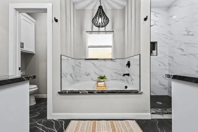 a large white kitchen with stainless steel appliances