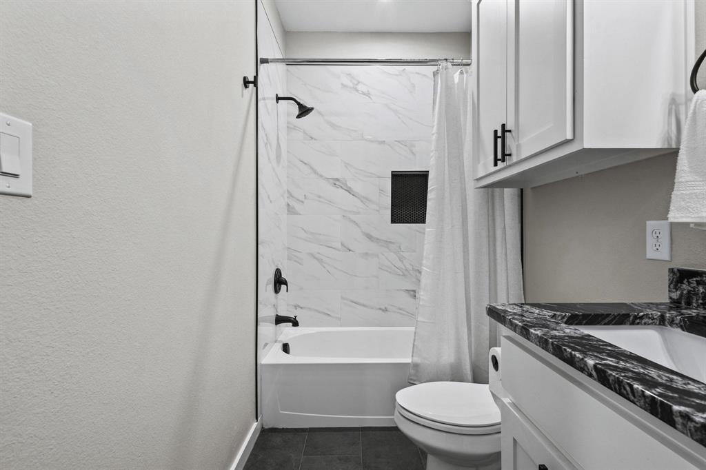 3632 County Road Blossom, TX 75416 - Photo 27 of 36 a bathroom with a granite countertop bathtub shower sink vanity and toilet