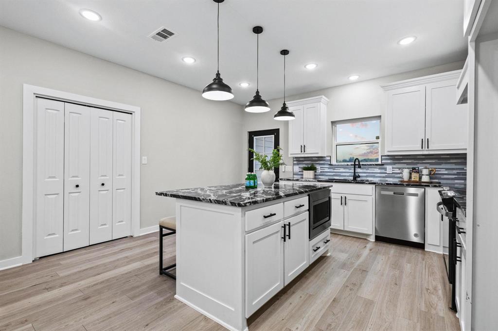 3632 County Road Blossom, TX 75416 - Photo 10 of 36 a kitchen with stainless steel appliances granite countertop a stove oven and white cabinets