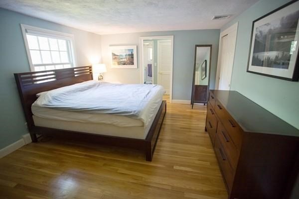 61 3 Ponds Road Wayland, MA 01778 - Photo 16 of 33 a spacious bedroom with a bed and wooden floor