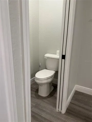 a white toilet sitting next to a wooden cabinet