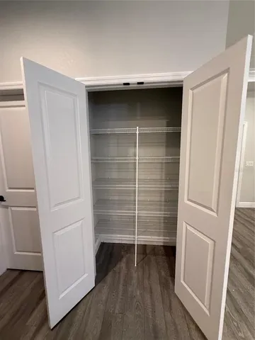a view of walk in closet with empty racks