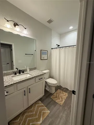 a bathroom with a double vanity sink toilet and mirror