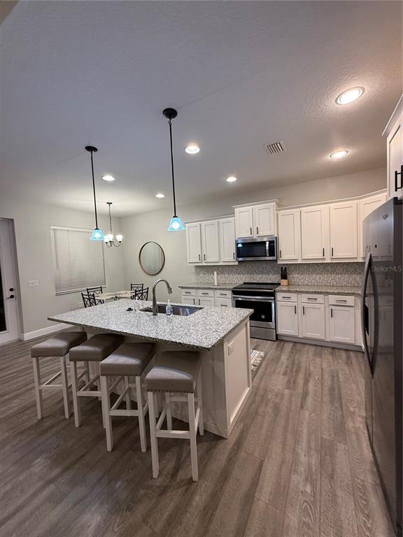 26267 Explorer Road Punta Gorda, FL 33983 - Photo 5 of 27 a large kitchen with kitchen island a sink table and chairs