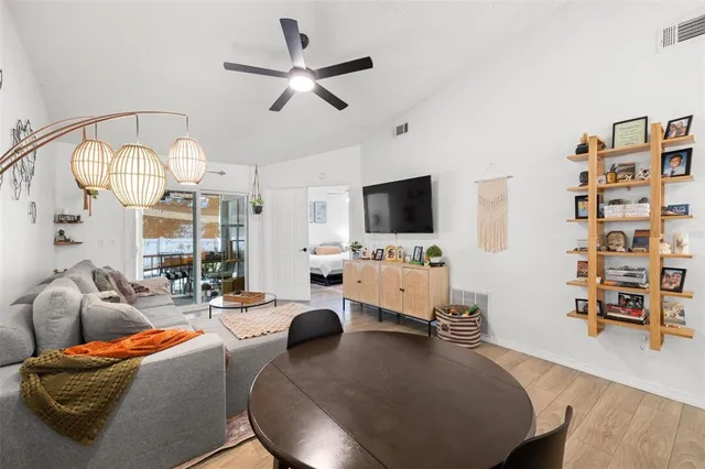 a living room with furniture a flat screen tv and kitchen view