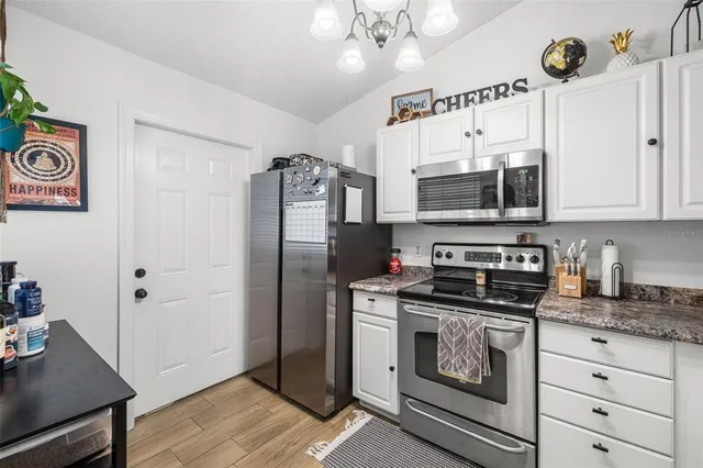 a kitchen with stainless steel appliances a stove a refrigerator and a microwave