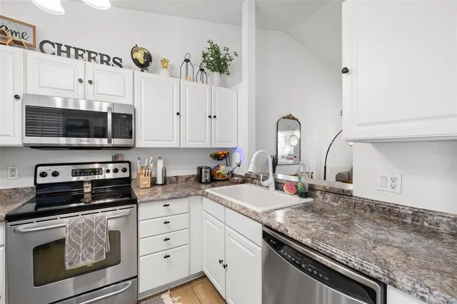 a kitchen with a sink stove and microwave