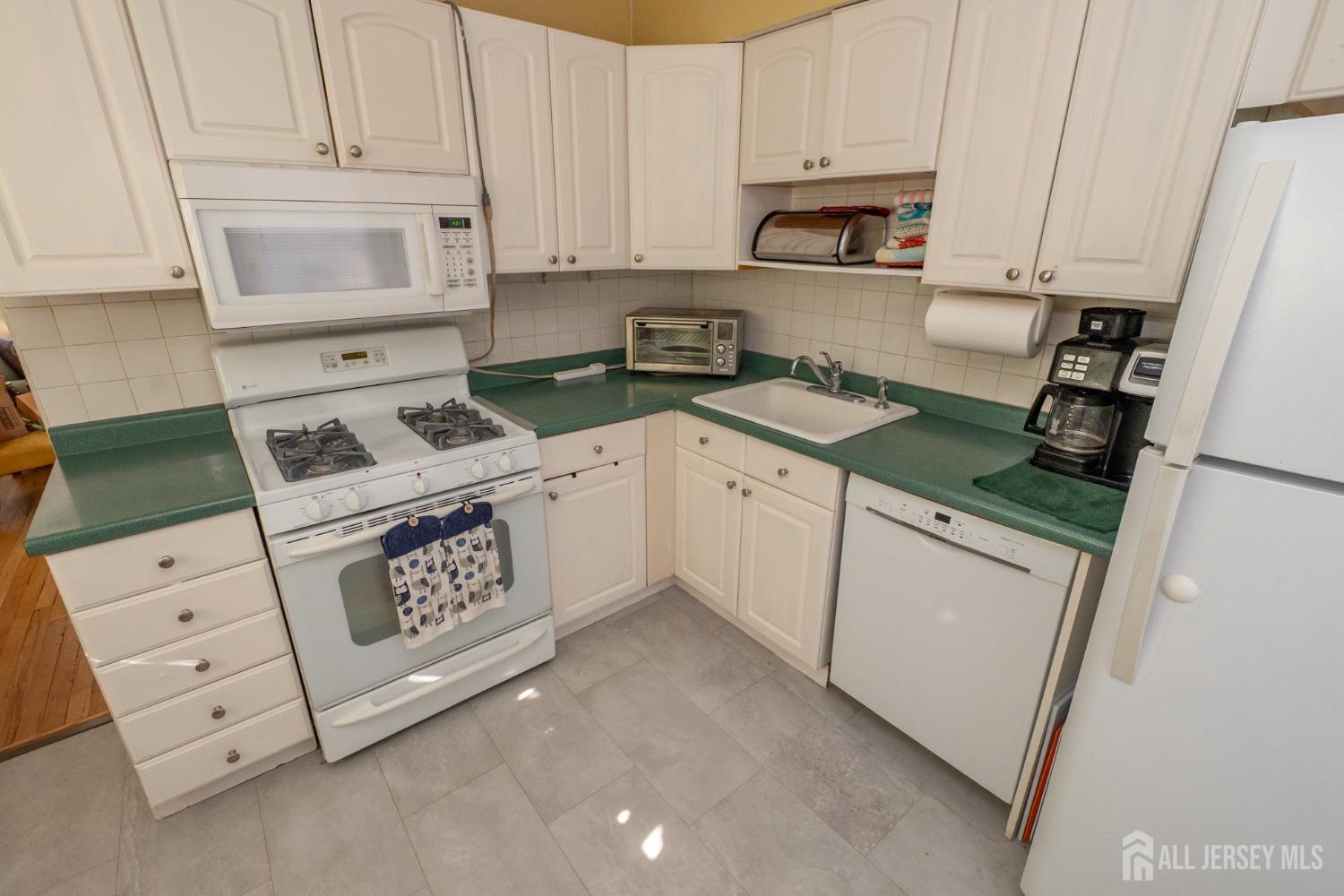 258 Sunset Avenue Old Bridge, NJ 08857 - Photo 21 of 27 a kitchen with white cabinets and white appliances