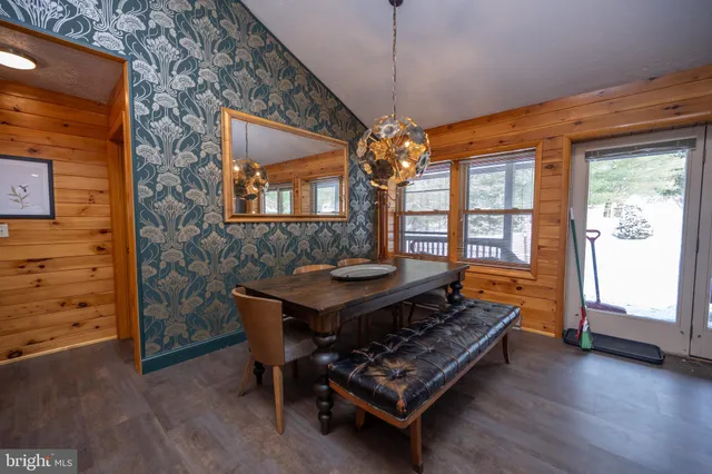 a living room with a table chairs and a chandelier