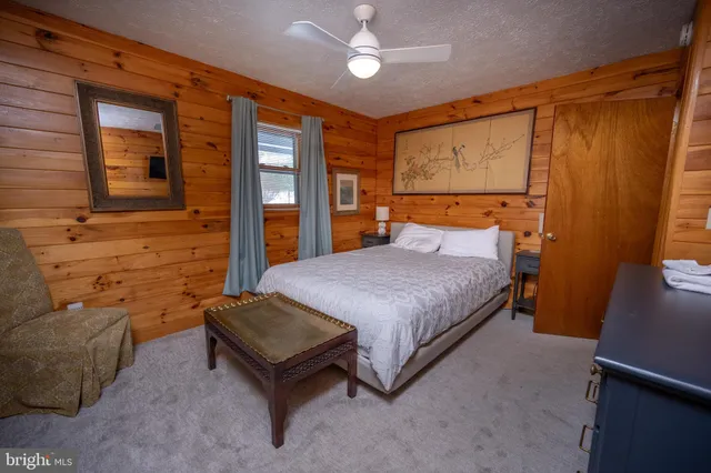 a spacious bedroom with a bed and wooden floor