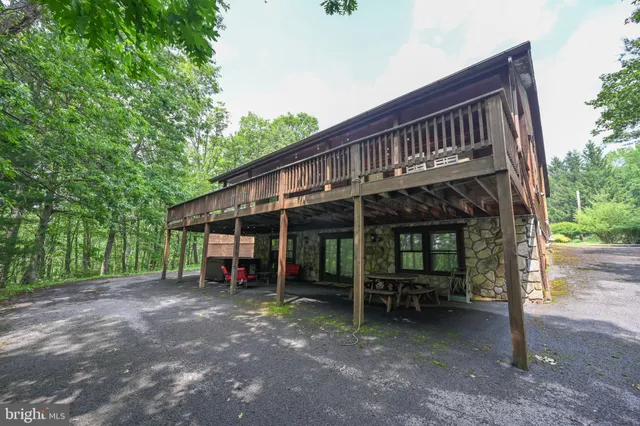 a view of a house with a yard and wooden deck