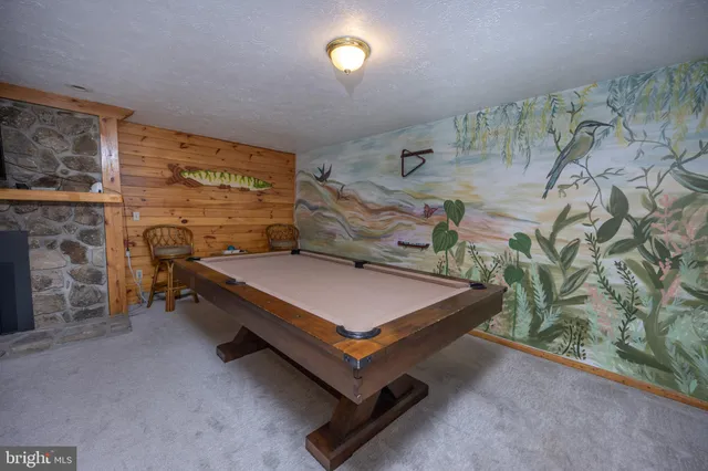 a living room with furniture pool table and a large window