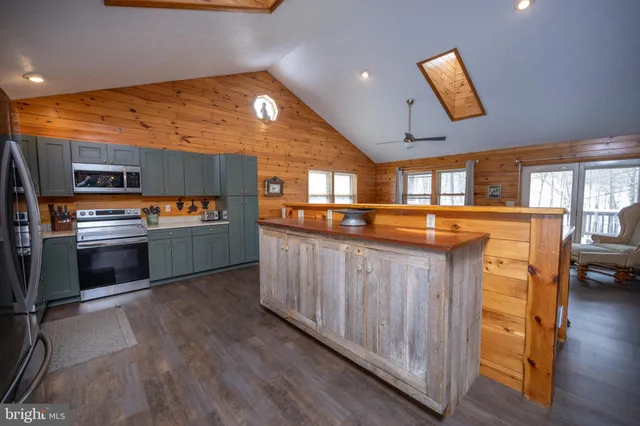 a kitchen with stainless steel appliances kitchen island granite countertop a stove a sink and a refrigerator