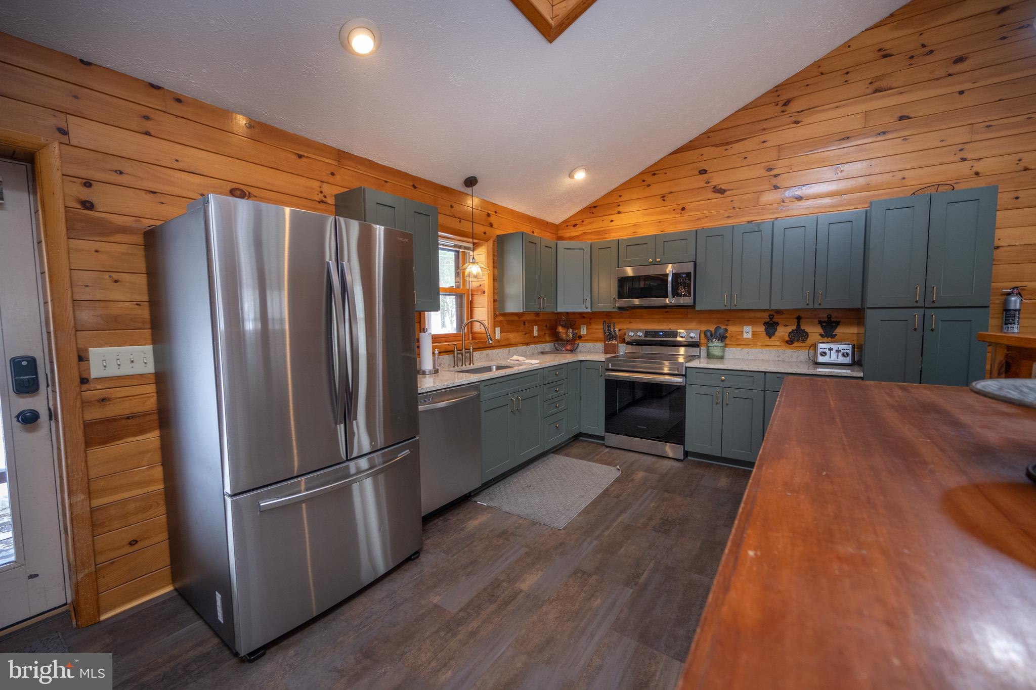 300 Normas Way McHenry, MD 21541 - Photo 5 of 48 a kitchen with stainless steel appliances a refrigerator a sink a stove a microwave and wooden floors
