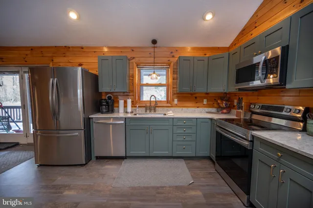a kitchen with granite countertop stainless steel appliances and wooden cabinets