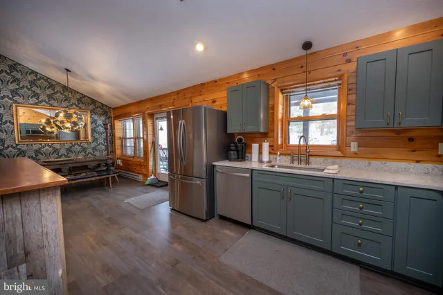 a kitchen with sink refrigerator and cabinets