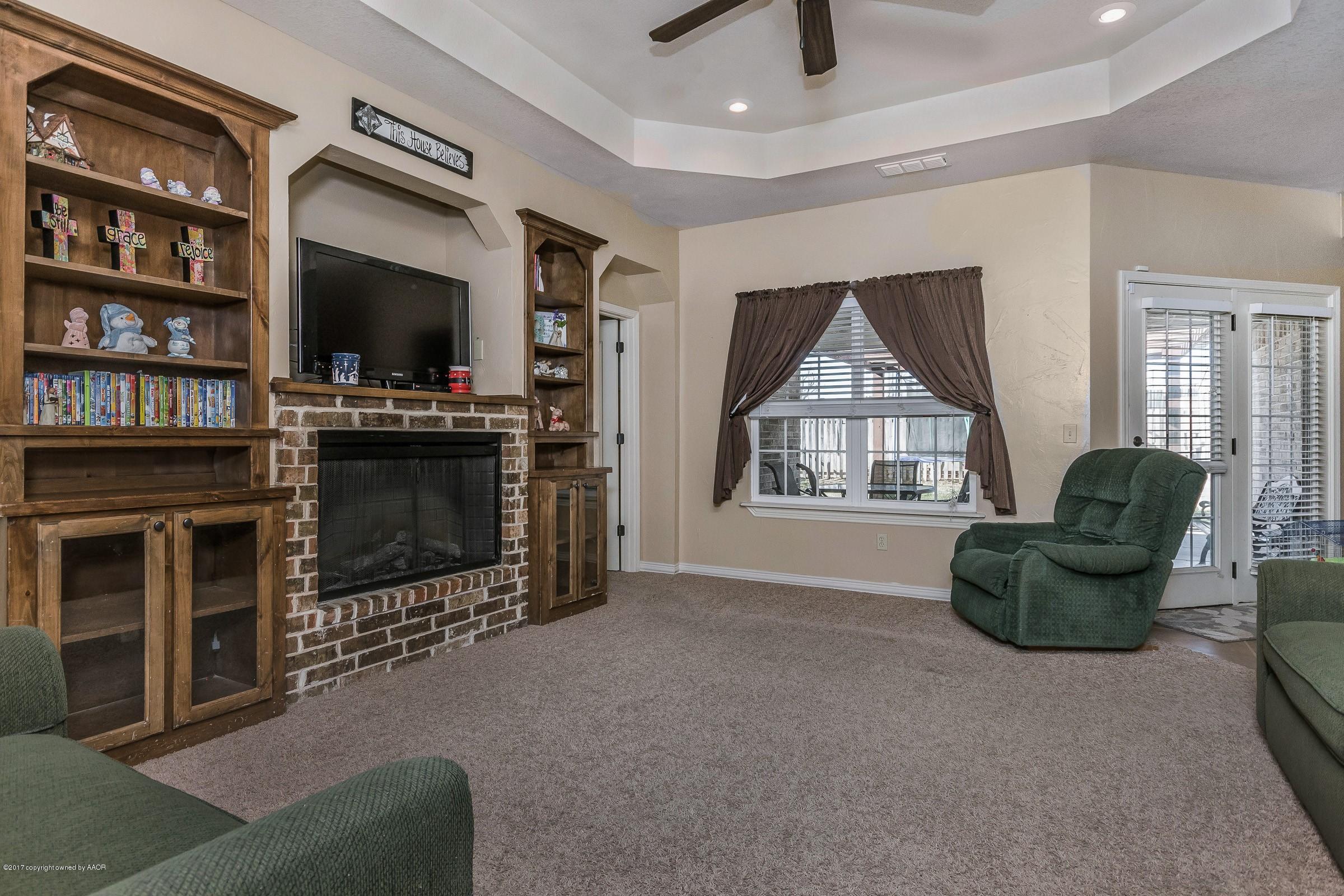 5308 Pleasant Court Amarillo, TX 79110 - Photo 2 of 19 a living room with furniture a flat screen tv and a fireplace