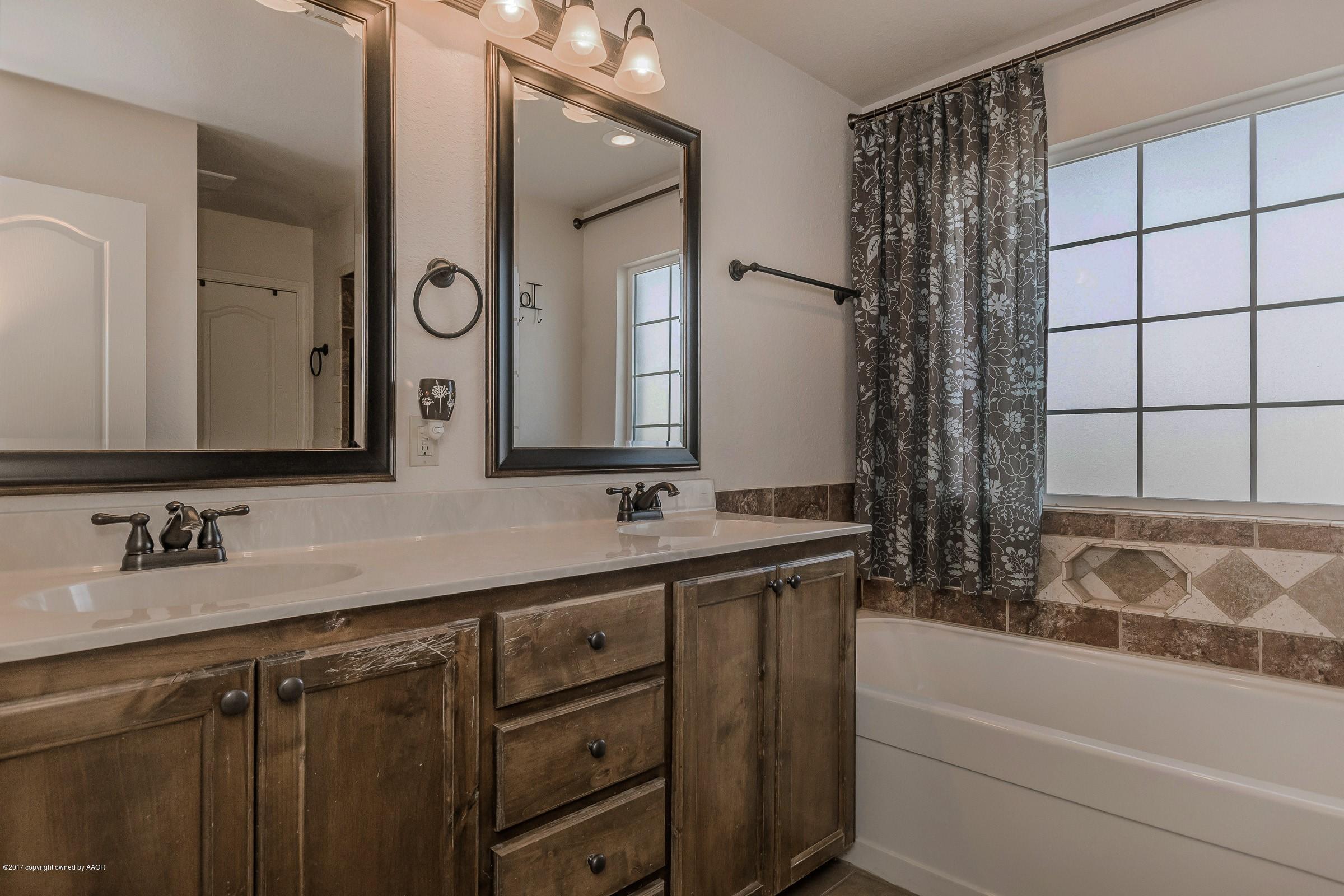 5308 Pleasant Court Amarillo, TX 79110 - Photo 5 of 19 a bathroom with a bathtub sink and mirror