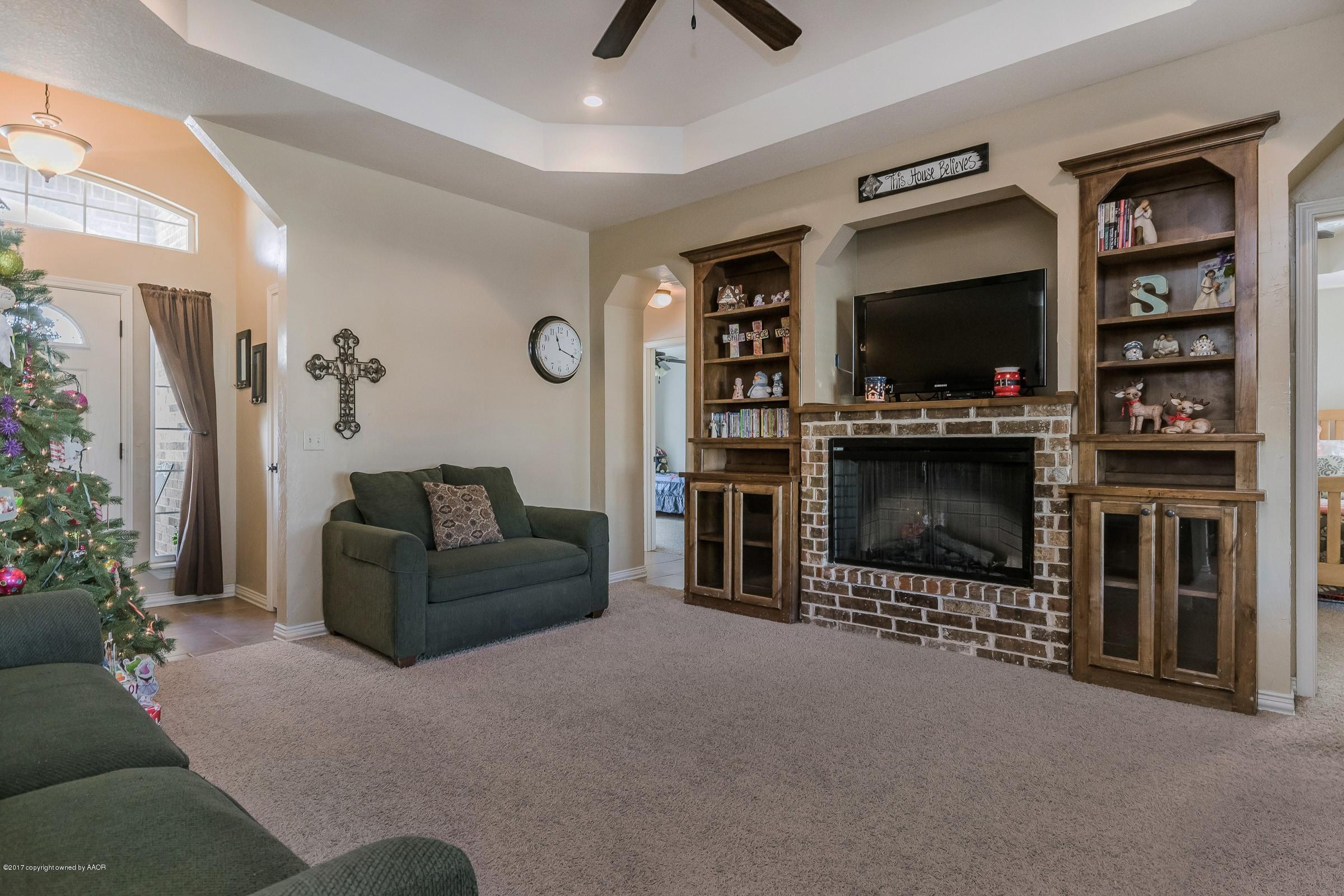 5308 Pleasant Court Amarillo, TX 79110 - Photo 7 of 19 a living room with furniture a flat screen tv and a fireplace