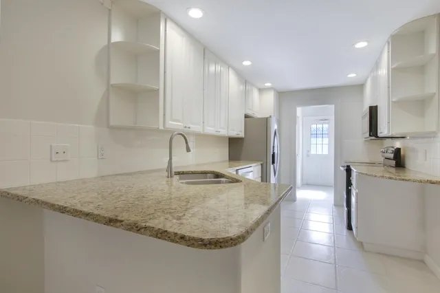 a kitchen with stainless steel appliances granite countertop a sink a stove and a refrigerator