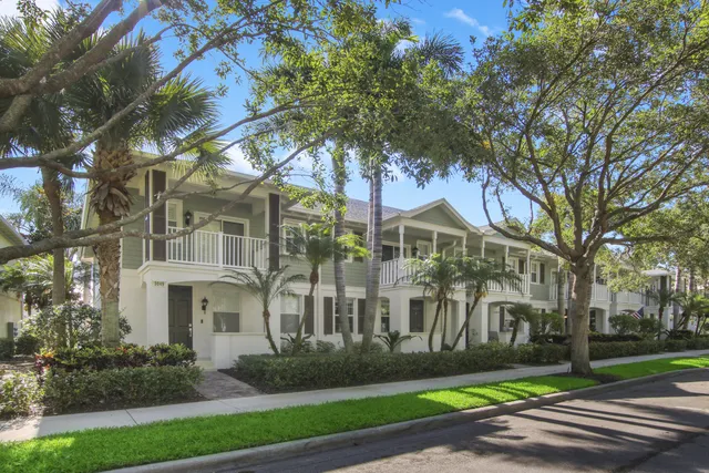 a front view of a house with garden and trees