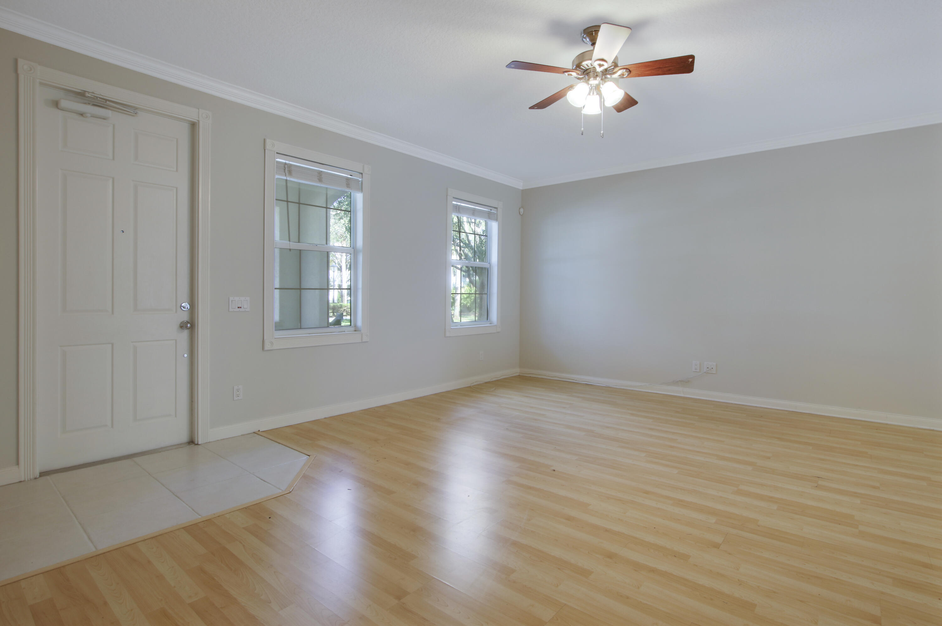 3057 East Community Drive Jupiter, FL 33458 - Photo 6 of 23 a view of empty room with wooden floor and fan