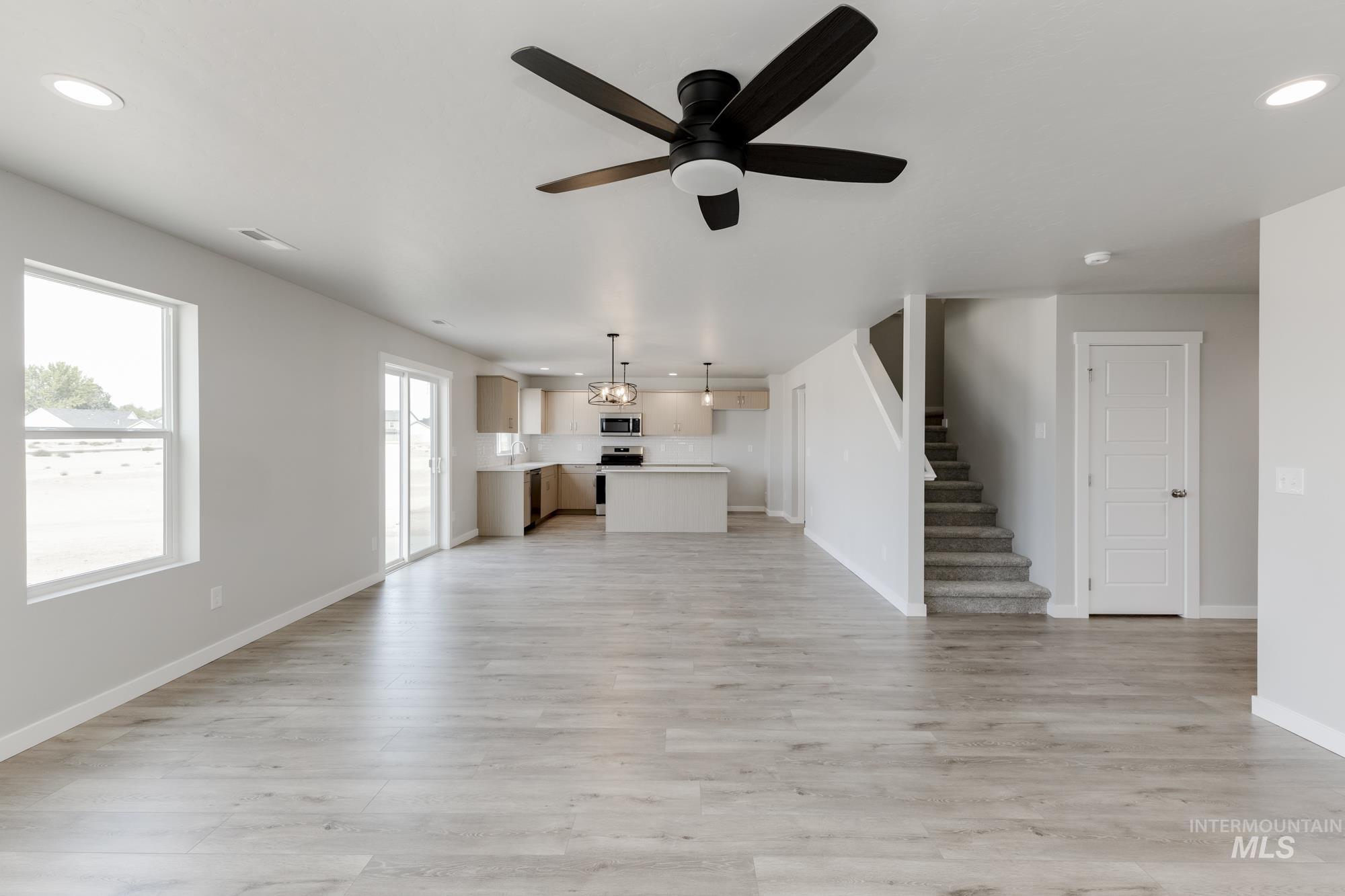 5303 Castleton Avenue Nampa, ID 83686 - Photo 11 of 26 Unfurnished living room featuring recessed lighting, a ceiling fan, light wood finished floors, and stairs