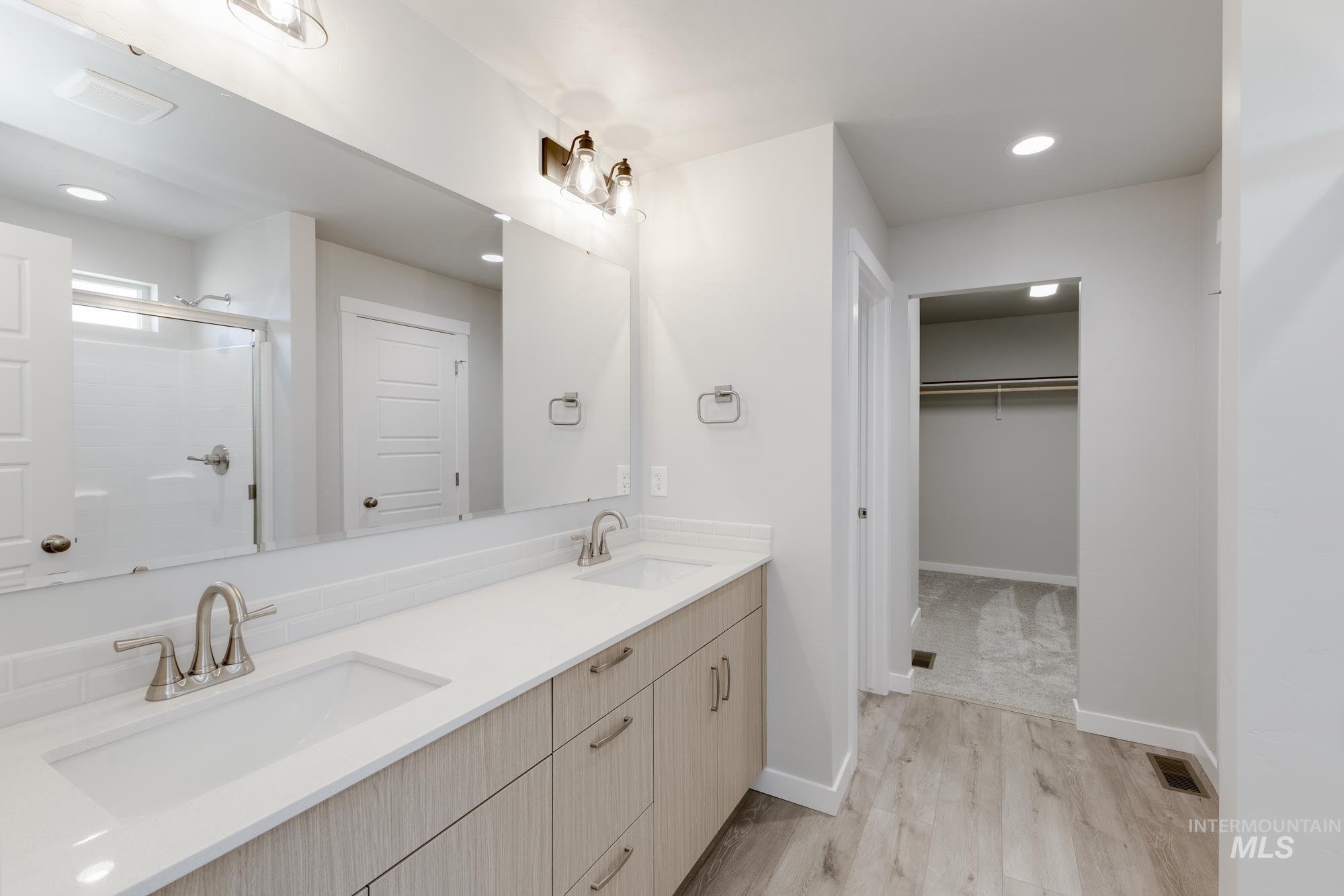5303 Castleton Avenue Nampa, ID 83686 - Photo 25 of 26 Full bath with a spacious closet, double vanity, light wood-type flooring, recessed lighting, and a shower stall