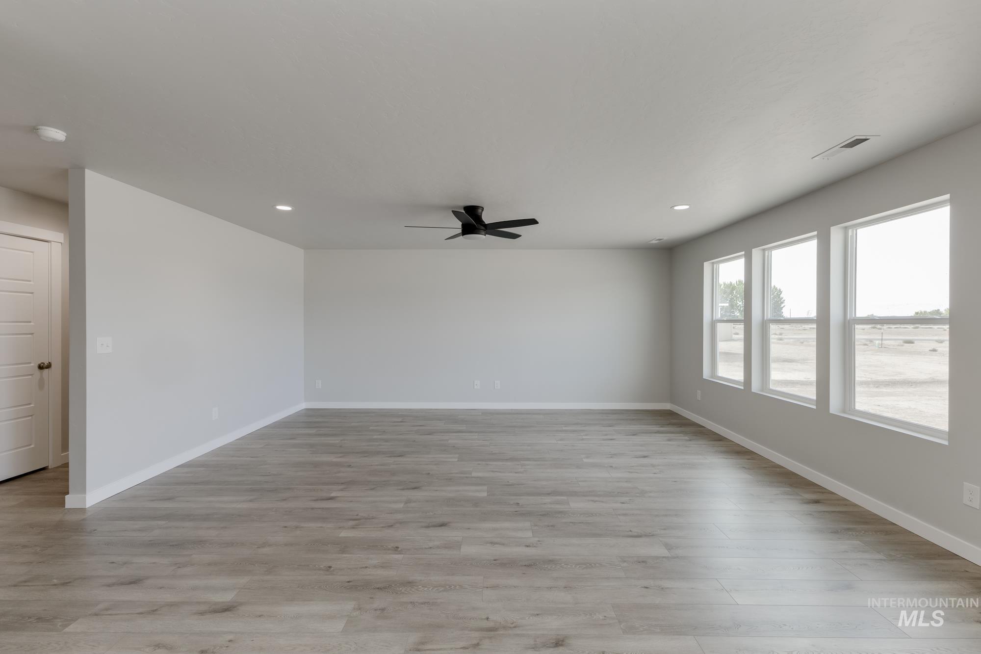 5303 Castleton Avenue Nampa, ID 83686 - Photo 9 of 26 Empty room with light wood-style floors, recessed lighting, and ceiling fan
