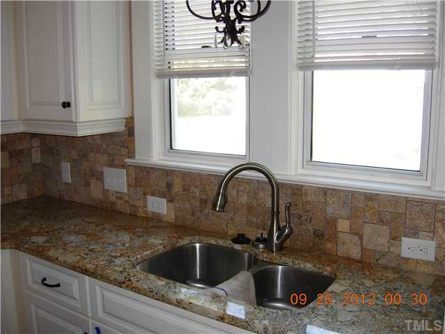 309 Hudson Street Raleigh, NC 27608 - Photo 6 of 17 a kitchen with granite countertop a sink stainless steel appliances and a window