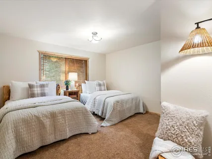 a bedroom with two beds and painting on the wall