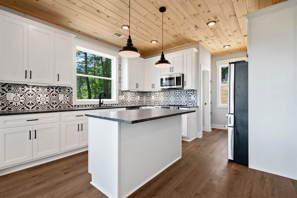 1374 Northeast Foxhound Ranger, GA 30734 - Photo 8 of 45 a kitchen with kitchen island granite countertop a sink cabinets and wooden floor