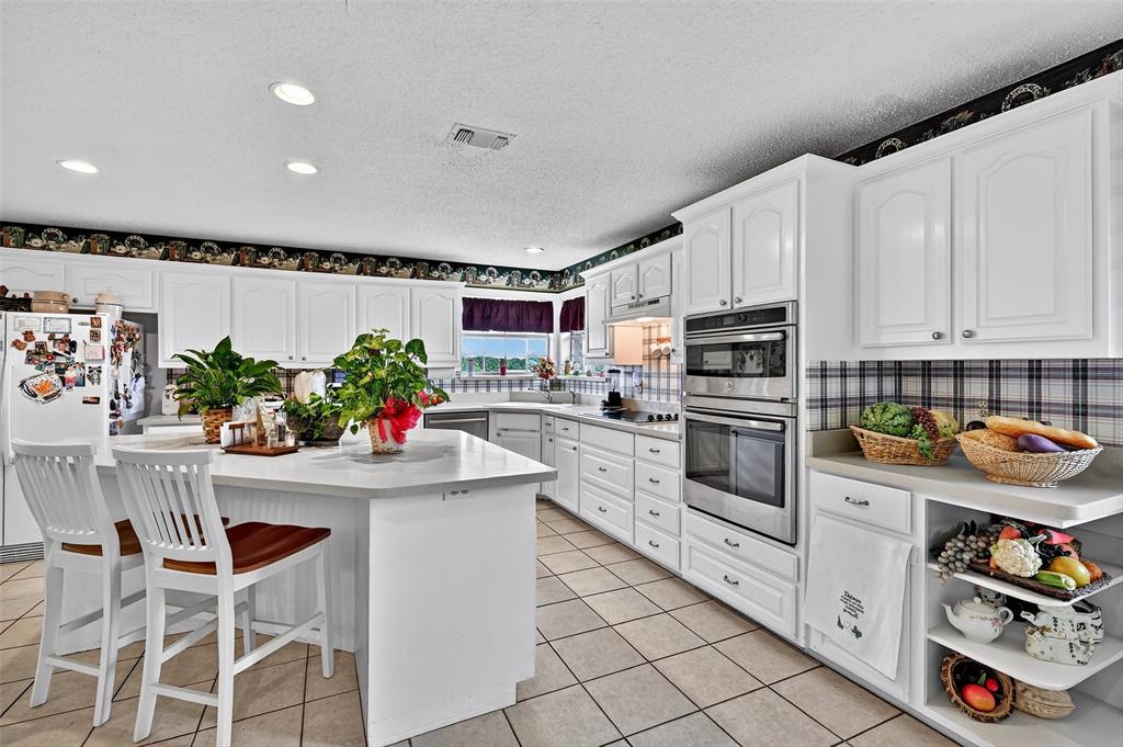 929 County Line Church Road Whitesboro, TX 76273 - Photo 19 of 38 a kitchen with granite countertop white cabinets and white appliances