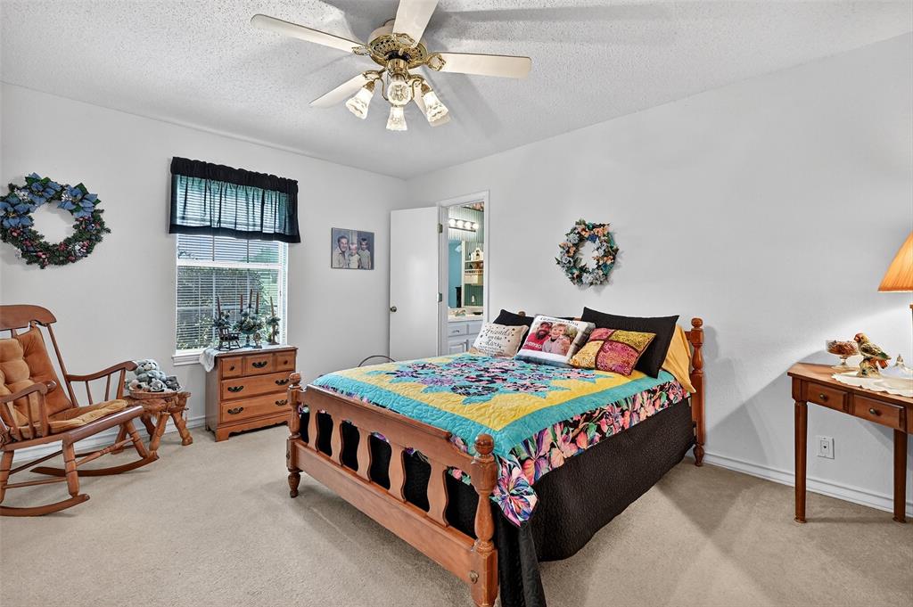 929 County Line Church Road Whitesboro, TX 76273 - Photo 21 of 38 a bedroom with a bed and a chandelier