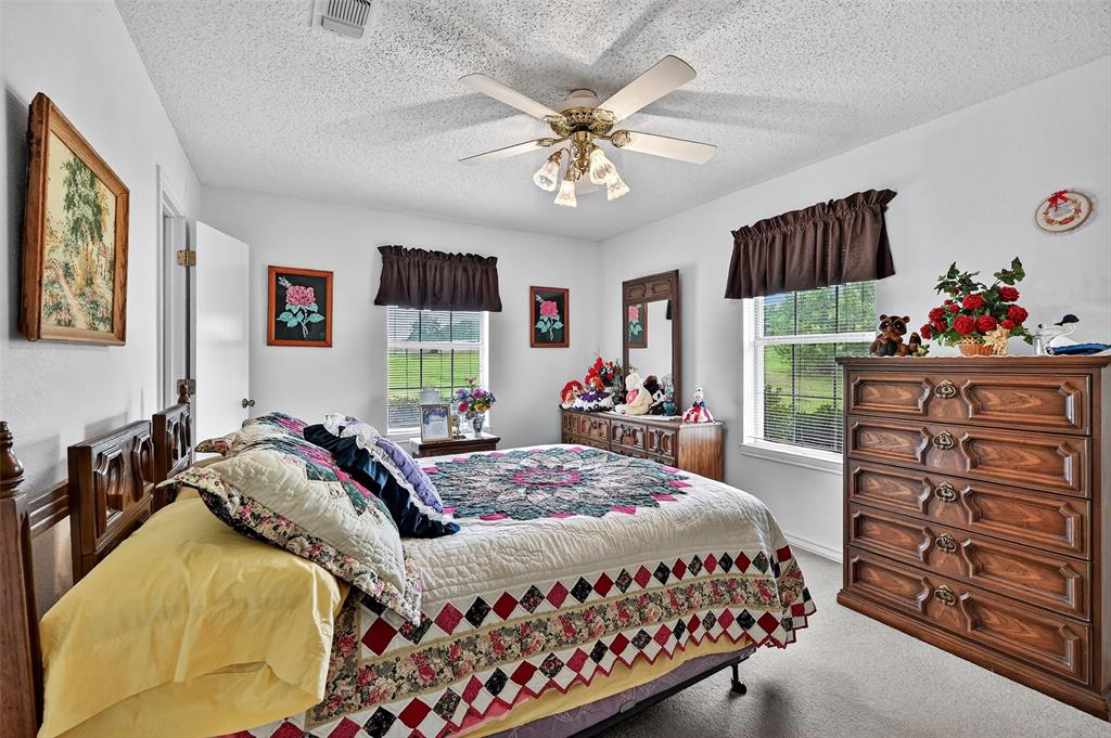 929 County Line Church Road Whitesboro, TX 76273 - Photo 23 of 38 a bedroom with a bed and a chandelier