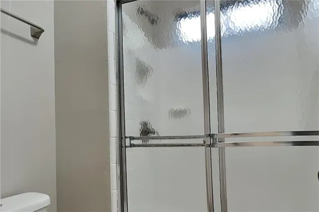 a bathroom with a granite countertop shower and a toilet