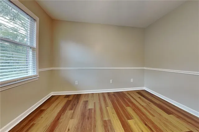 a view of a room with wooden floor and small window