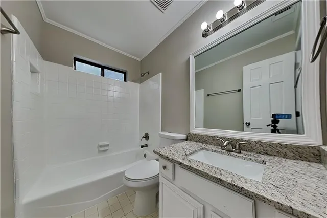 a bathroom with a granite countertop sink a toilet and shower