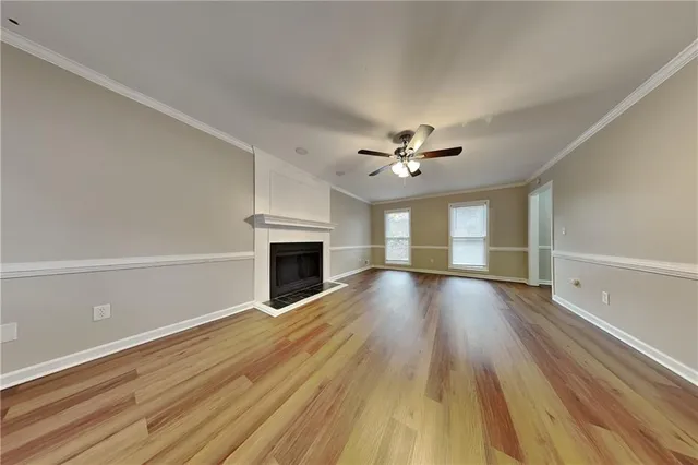 a view of empty room with wooden floor and fireplace