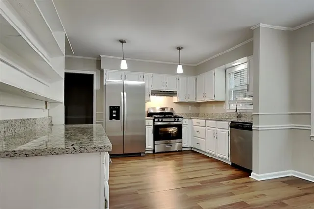 a kitchen with a refrigerator and a stove top oven
