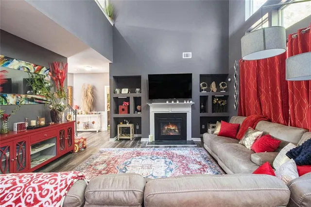 a living room with furniture a flat screen tv and a fireplace