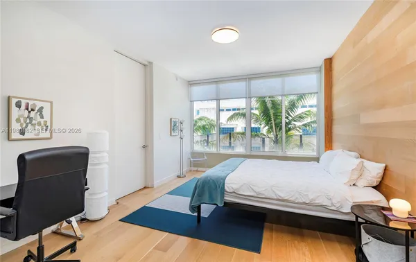 a bedroom with a bed and a large window