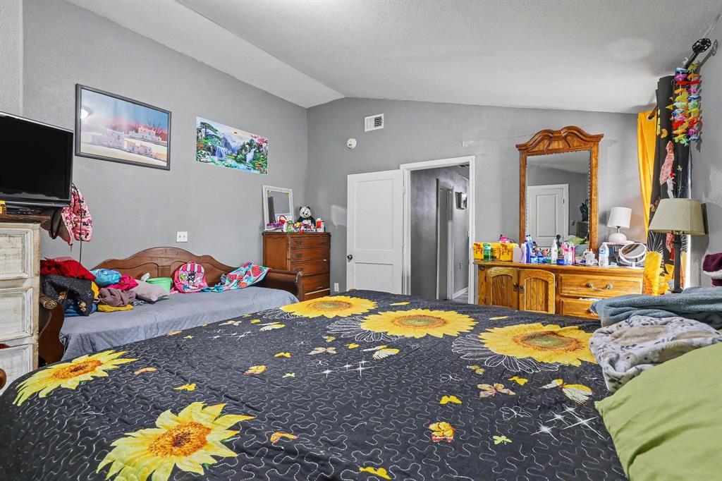 205 South Main Street Bonham, TX 75418 - Photo 16 of 23 a bedroom with a bed and a chandelier